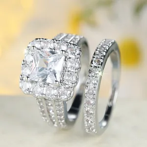 Elegante conjunto de anillos de boda con circonita cuadrada y pavé de halo en plata