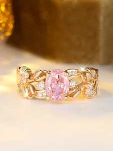 Macro shot of oval pink gemstone ring with leaf patterns and white diamond accents