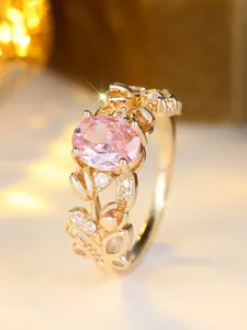 Macro shot of oval pink gemstone ring with floral leaf pattern and white zircon pavé