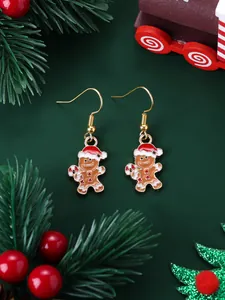 Macro detail of gingerbread man Christmas earrings with festive gold hooks and enamel finish