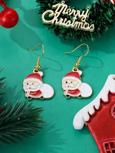 Detail of Christmas Santa Claus enamel drop earrings on festive green background