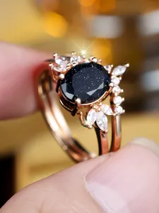 Macro-opname van roségouden dubbellaagse ring met ovale blauwe zandsteen en zirkonia
