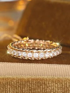 Makro-Detail des goldenen Eternity-Rings mit weißen Zirkonia und Kordelrand