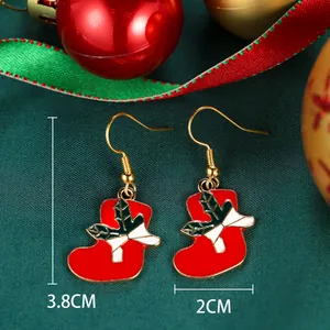 Detailed view of red Christmas stocking earrings with holly leaf and 3.8cm size mark