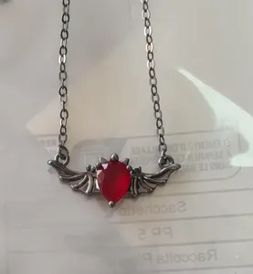 Makro-Detail des Gothic-Fledermausflügel-Anhängers mit rotem Edelstein am Halsband