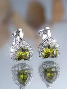 Détail de boucles d'oreilles cœur en argent avec pierres olive et zircons blancs