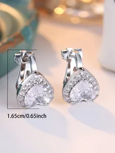Détail de boucles d'oreilles cœur avec zircons et mesure de taille de 1,65 cm