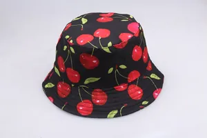 Detailed view of black reversible bucket hat featuring vibrant red cherry embroidery patterns