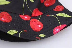 Double-sided sun hat featuring vibrant red cherry patterns on high-quality black canvas