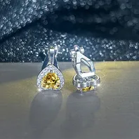 Détail de boucles d'oreilles halo en cœur avec zircon jaune et design de fermoir sûr