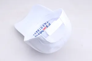 Detail des verstellbaren Klettverschlusses und der President-Stickerei auf der weißen Kappe