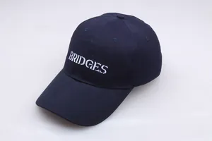 Detailaufnahme der dunkelblauen BRIDGES-Stickerei auf einer Premium-Baumwollkappe