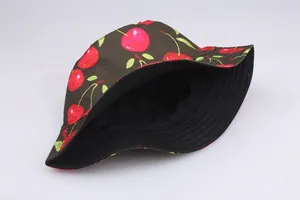 Detail of a dark brown cotton bucket hat with red cherry print and black inner lining
