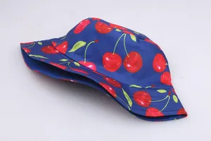 Detail shot of navy blue cotton bucket hat with vibrant red cherry and green leaf print
