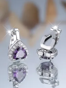 Détail de boucles d'oreilles cœur en zircon violet avec pavé de cristaux et reflet miroir
