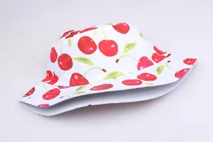 Close-up of reversible bucket hat with vibrant red cherry patterns and fine stitching