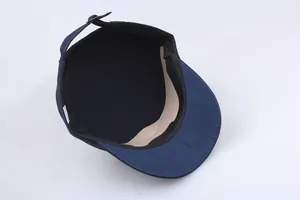 Inside view of navy military cap showing cotton fabric, sweatband and metal adjustment buckle