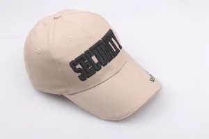 Close-up of detailed SECURITY embroidery on a khaki cotton outdoor baseball cap
