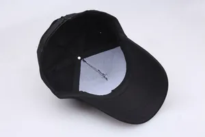 Detailed interior of a black baseball cap featuring 6-panel stitching and white reinforced lining