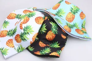 Détail de divers imprimés d'ananas sur des bobs en blanc, noir et bleu clair