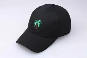 Detail of green palm tree embroidery on a premium black cotton baseball cap surface