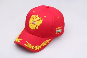 Close-up of golden Russian double-headed eagle and flag embroidery on a red baseball cap