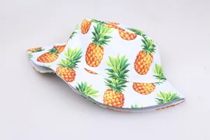 Détail d'un chapeau bob blanc avec imprimés ananas colorés et texture en toile de haute qualité