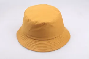 Minimalist turmeric yellow cotton fisherman hat with stitched brim on grey background
