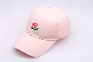 Close-up of red rose flower embroidery on pink cotton baseball cap with stitch detail