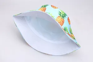 Vue détaillée du chapeau bob réversible avec motifs d'ananas jaunes sur toile bleu clair