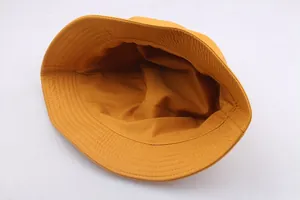 Minimalist yellow cotton bucket hat showing interior lining and reinforced stitching details