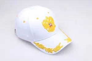 Close-up of golden eagle embroidery and laurel leaves on a white cotton baseball cap