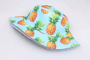 Détail de l'imprimé ananas et des coutures fines sur le tissu bleu du chapeau bob