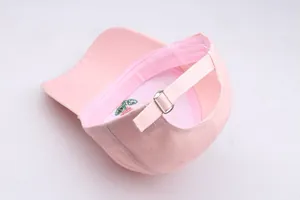 Detail view of pink baseball cap interior with metal buckle and rose flower embroidery