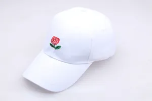 Close-up of a white cotton baseball cap featuring detailed red rose floral embroidery
