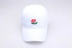 Close-up of a white cotton baseball cap featuring detailed red rose floral embroidery