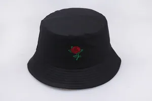 Detailed view of red rose embroidery on a black cotton bucket hat with stitching lines