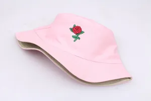 Detailed close-up of red rose embroidery on pink cotton bucket hat with dual-side design