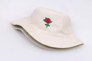 Close-up of red rose embroidery and reinforced stitching on a beige cotton bucket hat