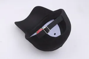 Detail view of the silver metal adjustment buckle and embroidery on the black baseball cap