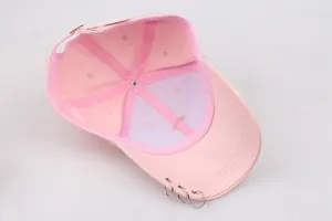Detail der Innenseite einer rosa Baumwollkappe mit silbernen Metallringen am Schirm