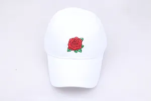 Close-up of vibrant red rose embroidery on a high-quality white cotton baseball cap