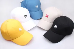 Lot de cinq casquettes en coton colorées avec broderie M sur fond blanc pour un look décontracté