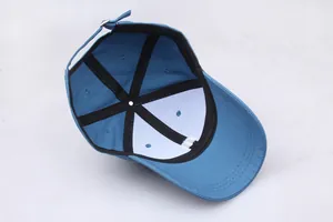Détail de l'intérieur d'une casquette bleue montrant les coutures et la boucle en métal