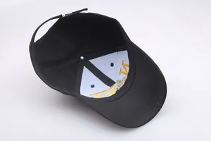 Detail of internal gold NY embroidery and metal buckle on black cotton baseball cap
