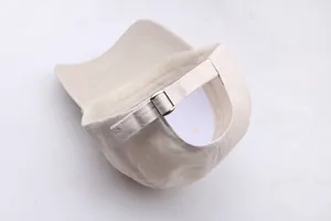 Détail de la boucle en métal réglable et texture du coton beige de la casquette