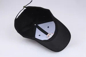 Detailed view of black cotton baseball cap interior with adjustable buckle and embroidery
