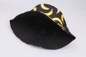 Reversible bucket hat with yellow banana print on black cotton fabric for street style