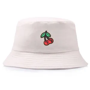 Japanese style beige bucket hat with embroidered cherry patches on a white background