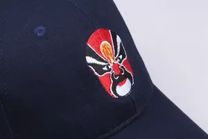 Close-up of traditional Peking Opera facial embroidery on navy blue cotton baseball cap